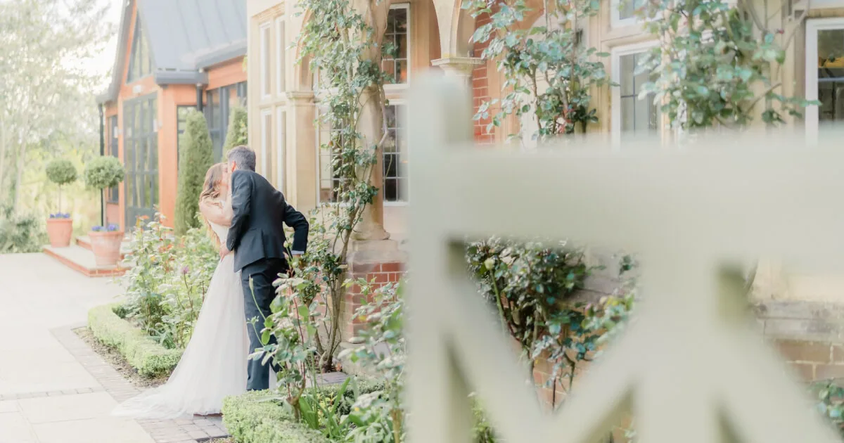 Bride and groom sharing a private moment outside venue gardens