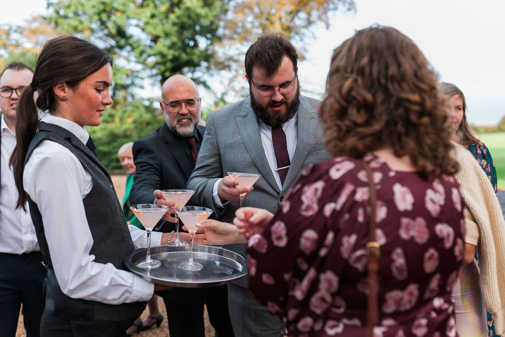 Wedding guests enjoying drinks served outdoors at Baddow Park House